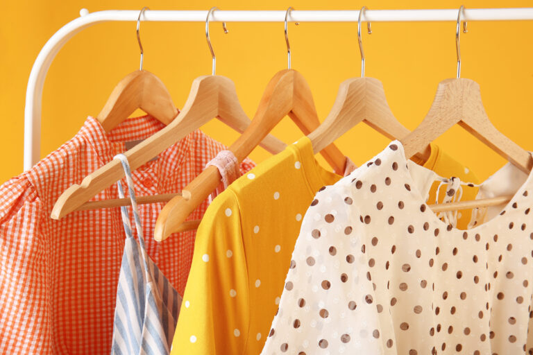 Rack,With,Hanging,Clothes,On,Color,Background,,Closeup