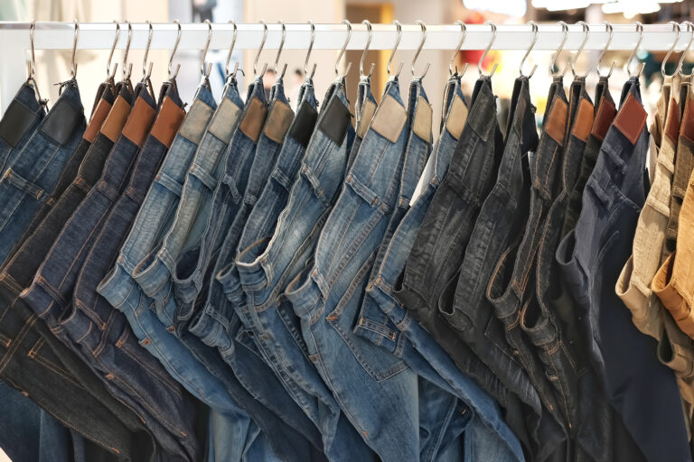 Many,Jeans,Hanging,On,A,Rack.,Row,Of,Pants,Denim
